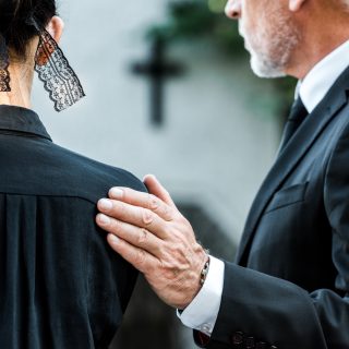 cropped-view-of-man-touching-woman-on-funeral.jpg